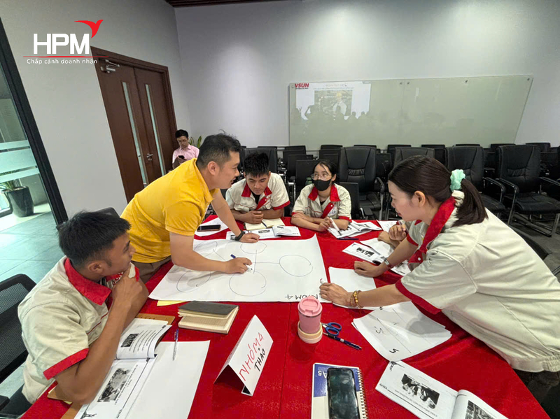 các anh chị thảo luận tại lớp đào tạo nâng cao kỹ năng quản lý